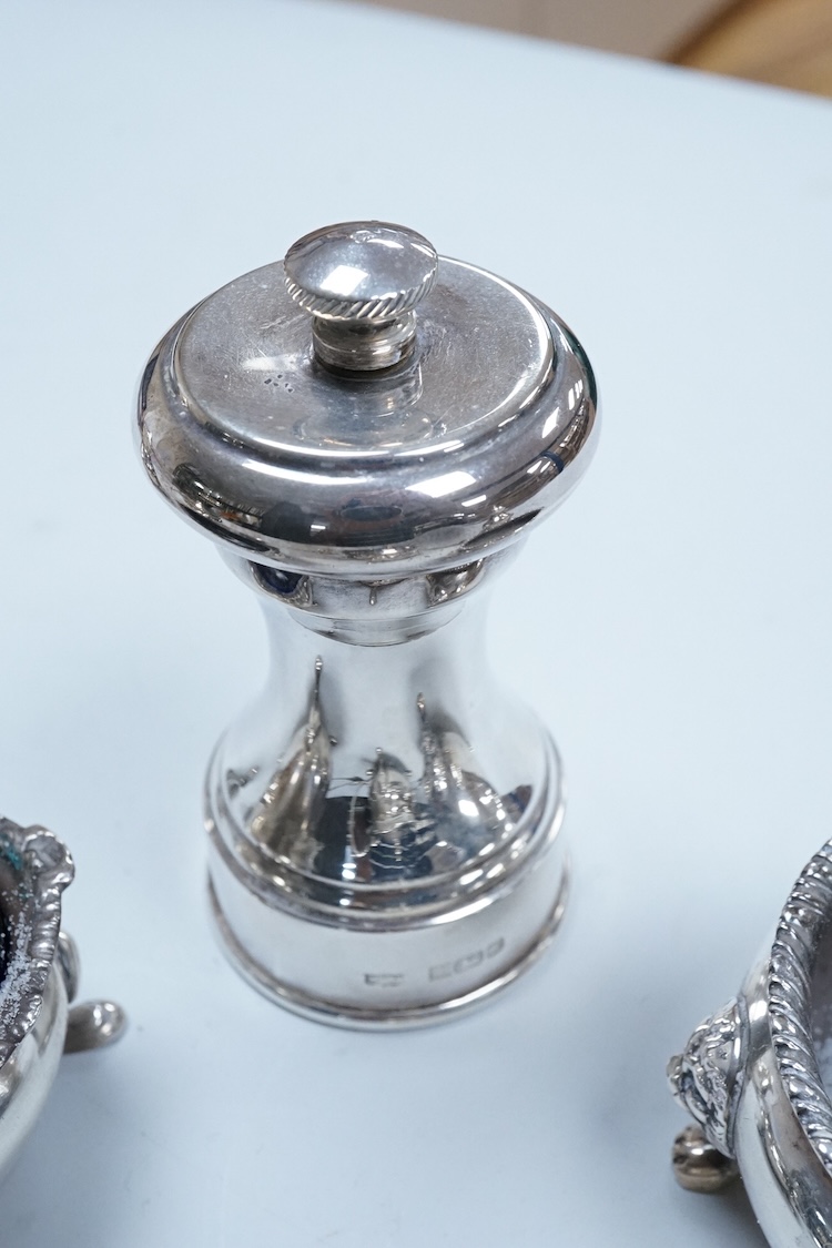 Two George VI silver three piece condiment sets by Walker & Hall, London, 1936/7, together with a modern silver mounted pepper mill by Mappin & Webb and two plated spoons.